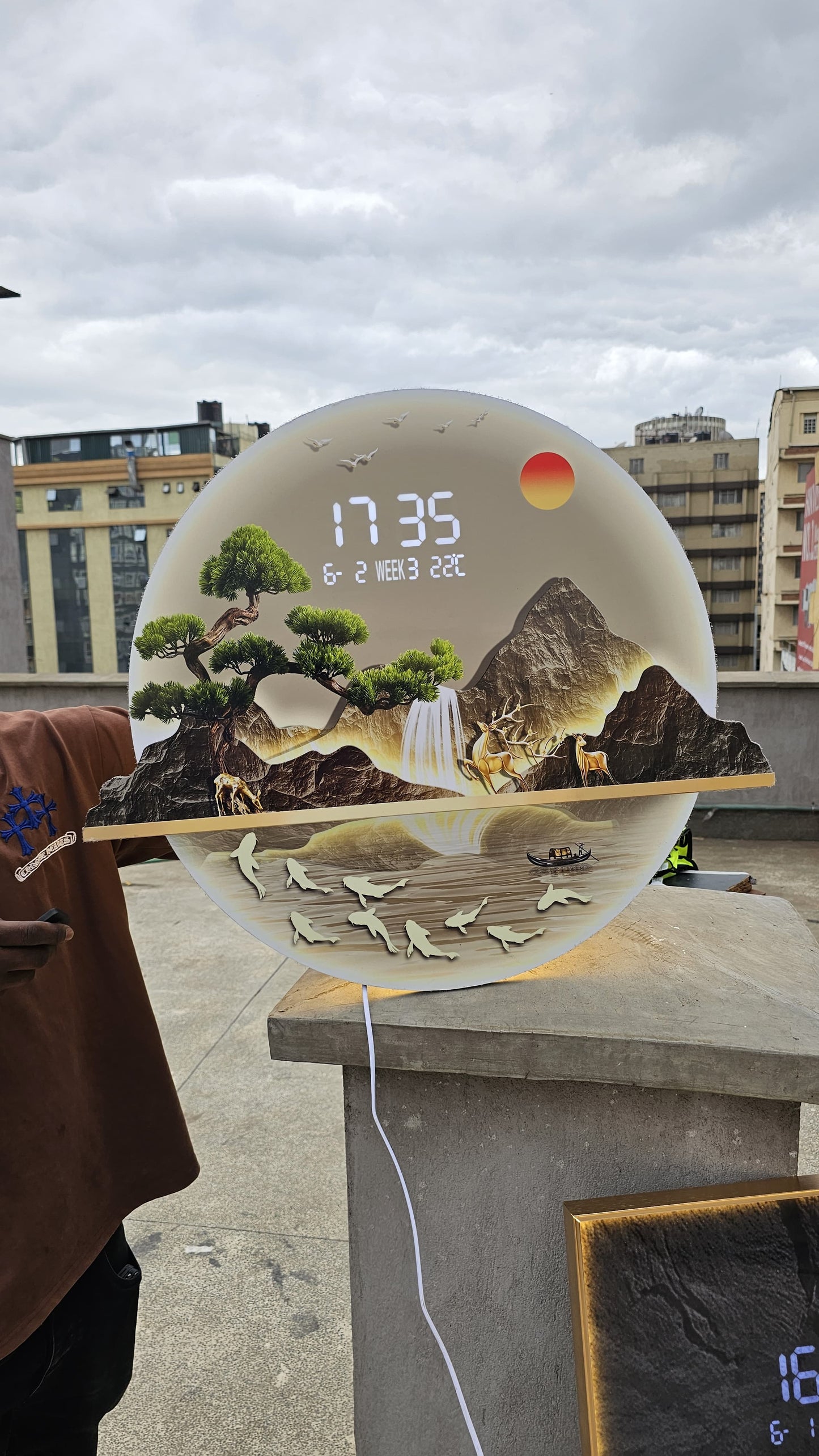 Bring modern elegance to your space with this LED Decorative Wall Clock featuring a stunning layered mountain landscape design and ambient warm backlighting.